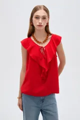 Blusa negra de viscosa sin mangas, con cuello redondo, volados frontales y detalle de lazo en el escote.