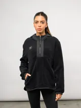 Buzo de polar negro con capucha, cierre frontal parcial y bolsillos laterales. Presenta detalles en nylon a tono en la capucha, la solapa del cierre y los bordes de los bolsillos, con el logo de la marca bordado en el pecho.