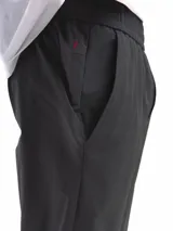 Pantalón casual color beige claro, de corte recto y tiro medio, con cintura elastizada y cordón ajustable. Presenta bolsillos laterales inclinados y costuras visibles en la parte delantera de las piernas.