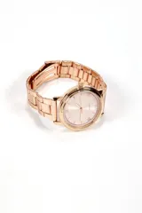 Reloj de pulsera dorado rosado con correa de eslabones y esfera redonda con números romanos.