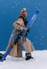 Trench midi color camel, confeccionado en mezcla de algodón y nylon. Presenta cuello clásico, cierre frontal con botones, tajos laterales y bolsillos internos. Es una prenda repelente al agua con diseño versátil y funcional.