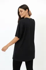 Remera de algodón de manga corta y cuello redondo, con diseño holgado y estampado frontal con motivos florales y texto.
