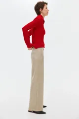 Pantalón de punto pesado color beige con acabado cepillado suave, de piernas rectas, cintura elástica y bolsillos delanteros tipo parche con botón.