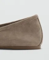 Zapato plano tipo chatita o ballerina de piel bovina en color taupe, con diseño clásico de punta redonda y pequeño detalle de lazo en el empeine.