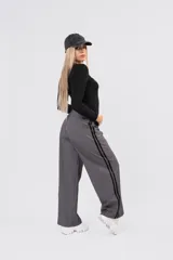 Pantalon de vestir gris con detalle de franjas laterales negras y etiqueta de marca Dolce en el bolsillo trasero.