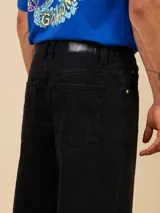 Jean de corte baggy fit en denim color azul claro, con diseño de cinco bolsillos y cierre frontal con botón metálico.