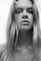 Vestido corto color blanco hueso en punto acanalado suave, con escote off-the-shoulder (hombros descubiertos) y doblez. Tiene mangas largas y una falda con vuelo.