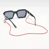 Correa para lentes roja con cuentas de cristal y terminales doradas.