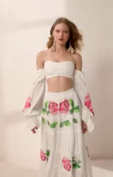 Falda larga blanca de corte en capas, con delicado bordado floral artesanal en punto de cruz con detalles en tonos rosados y verdes.