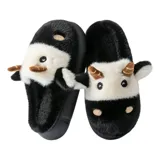 Pantuflas de peluche con diseño de vaca, confeccionadas en piel sintética suave. Cuentan con suela de goma antideslizante y diseño abierto en el talón.
