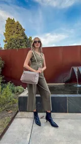 Bandolera de diseño práctico con combinación de texturas en tonos tierra, confeccionada en tela y símil cuero. Cuenta con un compartimento principal con cierre, un bolsillo frontal con cierre y correa ajustable para llevar al hombro o cruzada.