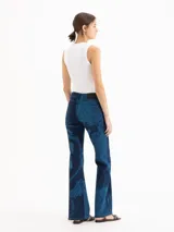 Jeans oxford de tiro medio-bajo, confeccionados en mezcla de algodón y elastano. Presentan un diseño ajustado hasta la rodilla y terminación acampanada, con un patrón gráfico de grabado láser cyanotype en tonos azules sobre base oscura.