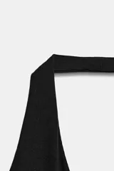 Mono de poliamida color negro con escote halter y escote en V profundo, de corte ajustado y largo por encima de la rodilla.