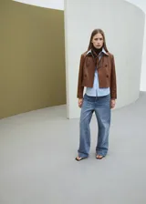Chaqueta de cuero de ovino en color marrón, de diseño corto y cruzado, con doble botonadura frontal y solapas clásicas.