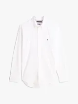 Camisa de vestir Tommy Hilfiger de color blanco, corte slim y manga larga. Presenta cuello camisero, cierre frontal con botones, puños abotonados con vuelta estampada en el interior y el logo de la marca bordado en el pecho.