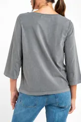 Remera de algodón lavada color gris, de corte al cuerpo, con escote redondo y mangas 3/4.
