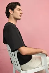 Remera negra de punto de algodón pesado, corte boxy holgado, con cuello redondo ribeteado acanalado, hombros caídos y bajo recto.