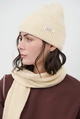 Gorro tipo beanie color beige de punto acanalado, con vuelta y etiqueta con el texto "Autumn.".
