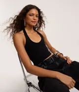 Blusa negra de punto roma, con diseño de cuello halter y espalda descubierta.