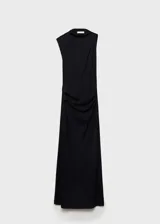Vestido largo de fiesta color negro, sin mangas, con cuello drapeado y detalle de fruncido en la cintura. Presenta un diseño recto con abertura lateral y tejido elástico.