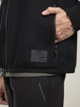 Campera verde oscuro con capucha, cierre frontal y bolsillos laterales.