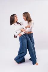 Pantalón de jean tipo wide leg con costura central vertical, tiro medio y corte holgado. Presenta un lavado denim clásico y cierre frontal con botón.