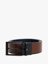 Cinturón reversible de cuero con hebilla metálica negra y detalle de logo de la marca. Diseño versátil con acabado liso.