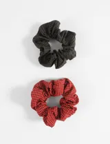 Set de dos gomitas para el pelo tipo scrunchie con estampado vichy: una en tonos marrón y negro, y otra en rojo y negro.