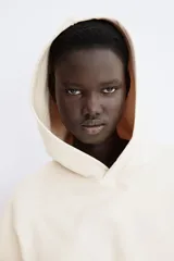 Buzo con capucha de doble capa, hombros caídos y bolsillo canguro frontal. Presenta puños y bajo acanalados.