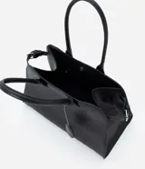 Cartera modelo stachel de tamaño grande, confeccionada en poliuretano color negro. Presenta asas cortas, cierre superior con botón a presión y detalles metálicos decorativos.