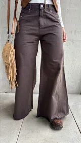 Jean de corte wide leg en color chocolate, confeccionado en denim con costuras verticales decorativas y ruedo deshilachado.