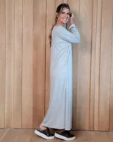 Vestido largo de lanilla en color gris melange, de corte holgado y diseño minimalista. Presenta cuello redondo, mangas largas y un bolsillo frontal tipo parche en el pecho.