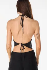Top halter de tencel color beige con silueta asimétrica y diseño minimalista.