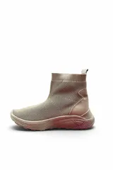 Bota tipo zapatilla de caña alta confeccionada en tejido de malla y material sintético, color beige, con suela robusta y diseño tipo slip-on.
