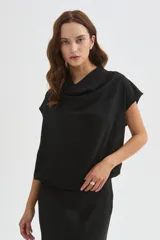 Blusa de poliéster color marfil, de corte holgado, sin mangas y con cuello buche drapeado.