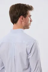 Camisa de manga larga con diseño de cuadros vichy en tono celeste y blanco, cuello abotonado y bolsillo frontal en el pecho con logo bordado.
