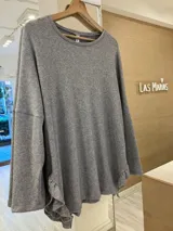 Buzo de lanilla con lurex color negro, de corte holgado y mangas largas. Presenta volados en los laterales inferiores.