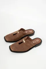 Zuecos de cuero color bordó con punta cuadrada, detalle de abertura en el empeine y aplique metálico dorado.