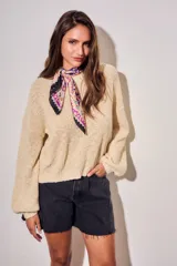 Sweater de tejido bouclé texturado color beige, con cuello redondo y mangas largas holgadas de corte amplio.