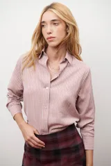 Camisa de mujer a rayas verticales blancas y rosadas, con cuello clásico, cierre de botones frontal y mangas largas con puños abotonados.