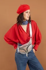 Riñonera plateada con correa de cuero vacuno color whisky y marrón liso. Tiene dos bolsillos externos con cierre y correa metálica trenzada.