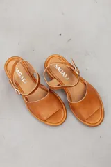 Sandalia de cuero marrón con diseño open-toe, tira ancha en el empeine, correa ajustable con hebilla en el tobillo y tacón ancho de madera.