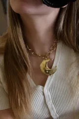 Collar dorado con cadena de eslabones gruesos y dije de luna creciente.