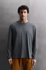 Camiseta de entrenamiento de manga larga y cuello redondo, confeccionada en tejido técnico ligero y elástico con tecnología de secado rápido. Presenta costuras planas para mayor resistencia y comodidad durante el movimiento, con un pequeño logo estampado en el bajo.