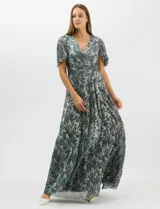 Vestido largo de fiesta con diseño cruzado, escote en V y drapeado lateral en la cintura. Presenta mangas cortas acampanadas y falda amplia con caída fluida. Confeccionado en tejido liviano con acabado plisado y estampado floral metalizado.