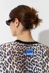 Vestido largo de poliéster con estampado animal print y cuello redondo con ribete negro.