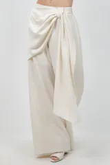 Pantalón beige de pierna ancha, confeccionado en tela suave con finos destellos dorados, diseño forrado y sobre tela drapeada a modo de cinturón.