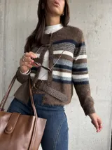 Saco tejido de punto con diseño a rayas horizontales en tonos marrón, blanco y gris. Presenta cuello redondo, cierre frontal con botones y mangas largas.