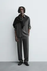Pantalón de corte relaxed fit, con cintura ajustable, bolsillos delanteros y bolsillo trasero de plastrón. Presenta cierre frontal con cremallera y botón.