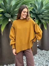 Sweater de lana color rosado, con cuello alto y detalles de volados en los hombros y puños.